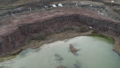 High-reverse-Aerial-view-drone-flight-over-lake-in-Kinnekulle-Sweden