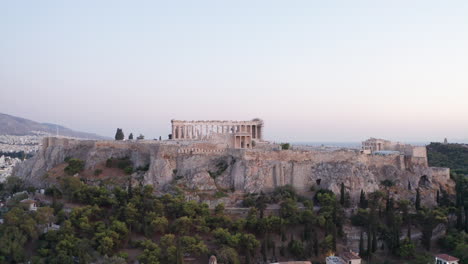 aerial video flying up from the streets of athens to see the acropolis sitting on top of a rocky hilltop