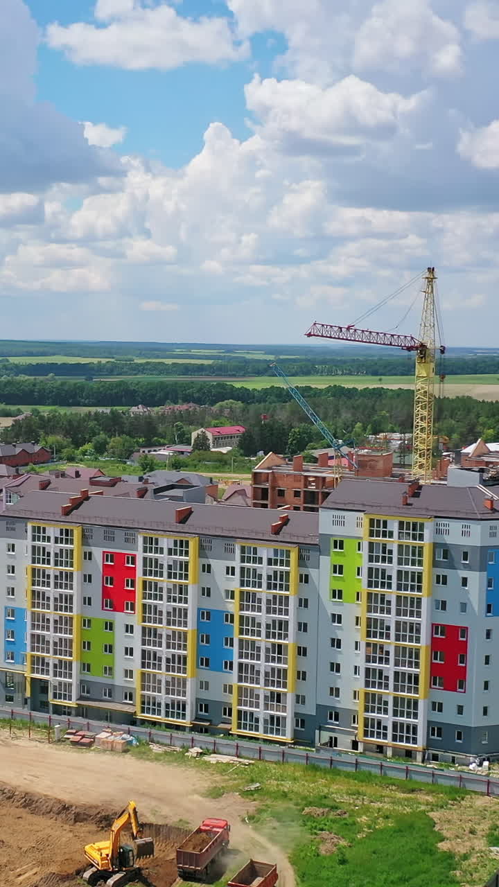Modern district on the outskirts of a city. New multi storey buildings on the construction site. Building new residential complex. View from the air. Vertical video