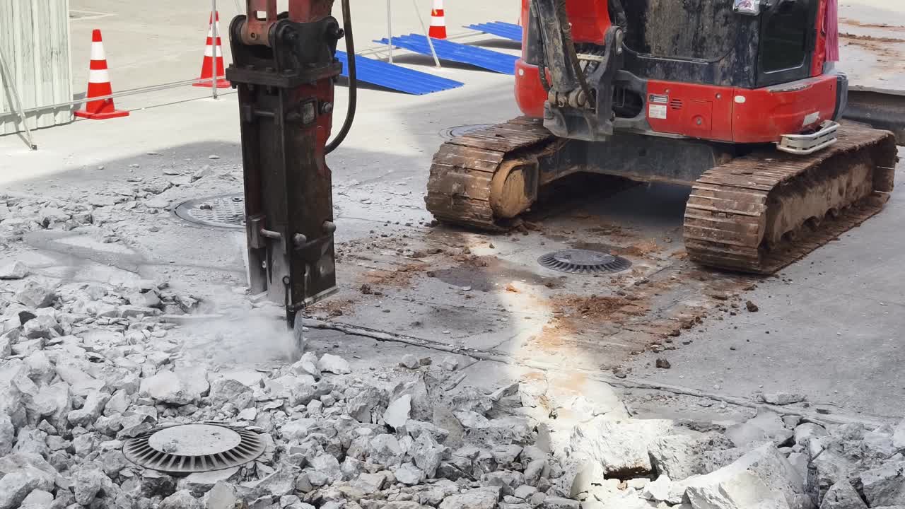 mini excavadora con rompedor para demoler el pavimento de hormigón