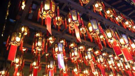 ceiling lamps with red bows and cards in tin hau temple, hong kong