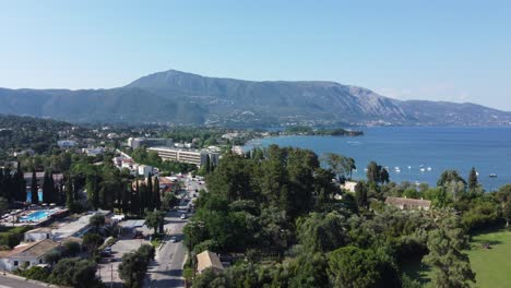 carretera costera cerca de la bahía de ipsos, corfú, grecia, con vistas a centros turísticos y montañas verdes exuberantes