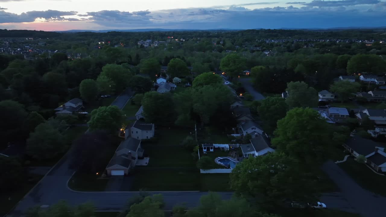 Luxury neighborhood in suburb with Swimming pol in garden. Dawn scene in the morning. Aerial lateral wide shot. Geren trees in spring season. Houses and homes in suburbia of United States. Quiet scene