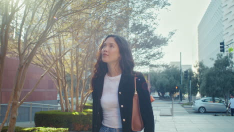 walking girl smiling on sunlight on street. asian brunette enjoying cityscape.