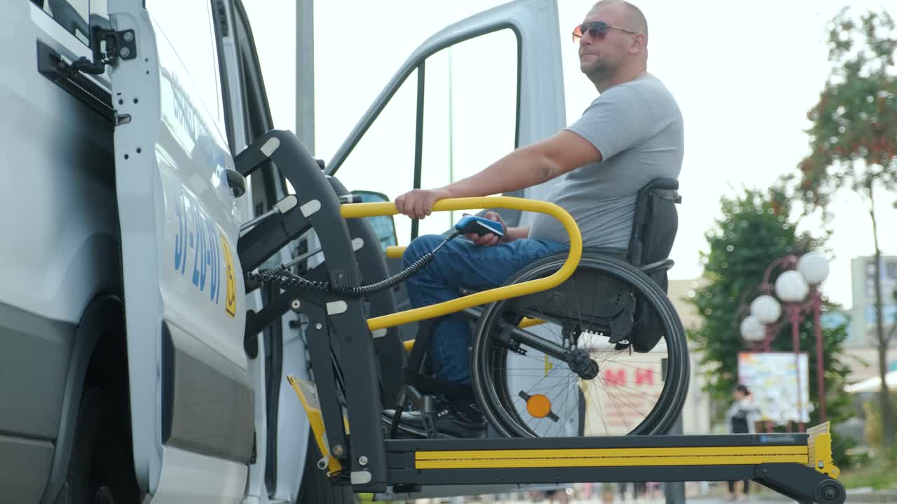 um homem em cadeira de rodas num elevador de um veículo para pessoas com deficiência. equipamento de elevação para pessoas com insuficiência - homem em cadeiro de rodas perto do veículo
