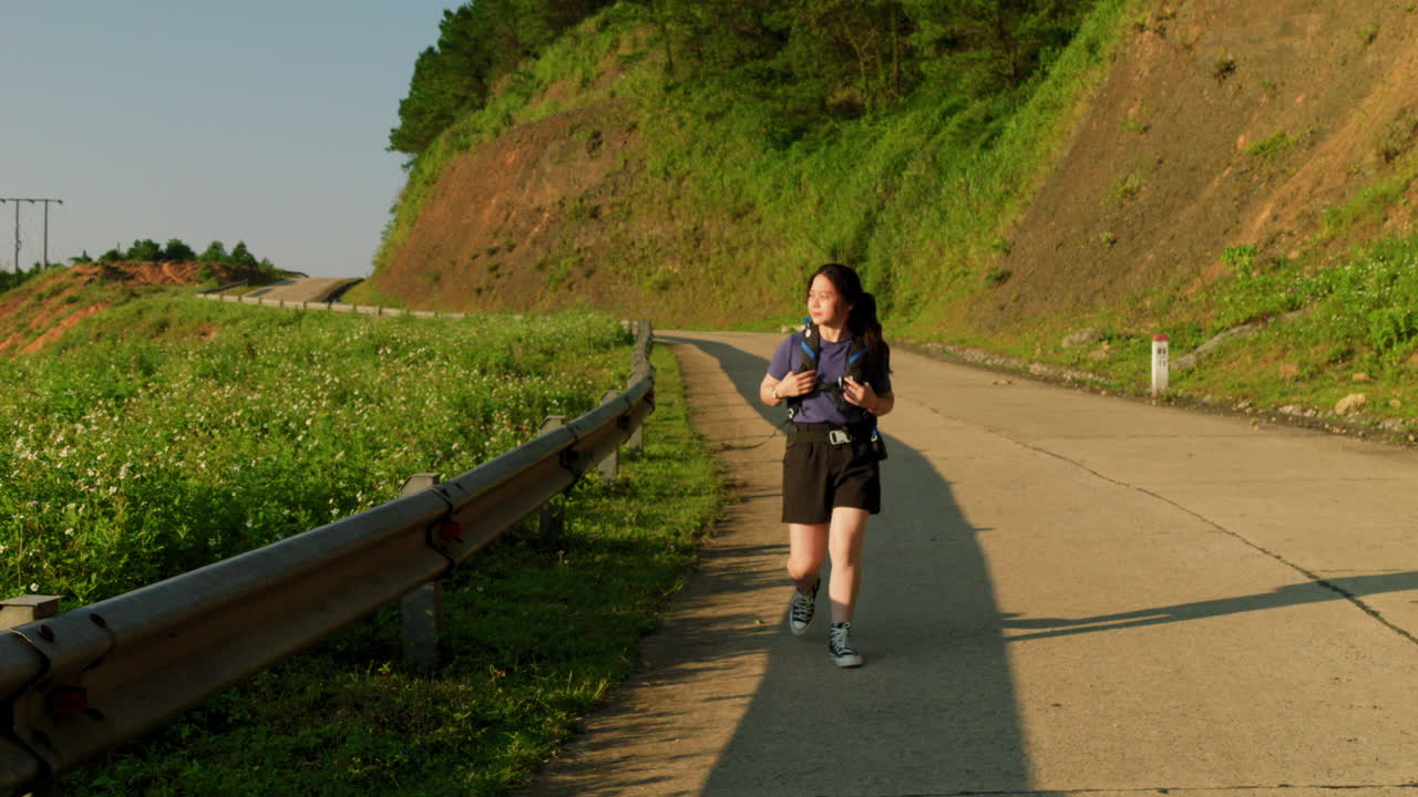 시골 시골의 산길에서 배 ⁇ 과 함께 트레킹하는 슬로우 모션 솔로 여성 여성