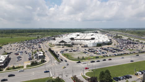 Drone-push-in-above-apartment-building-to-sprawling-outlet-mall-and-packed-full-parking-lot