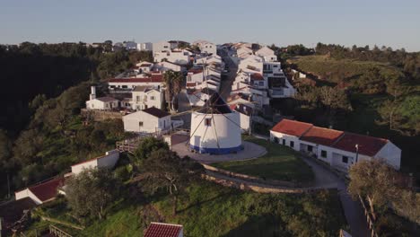 volando hacia atrás en el viejo molino de viento típico portugués odeceixe durante la mañana temprano, aéreo