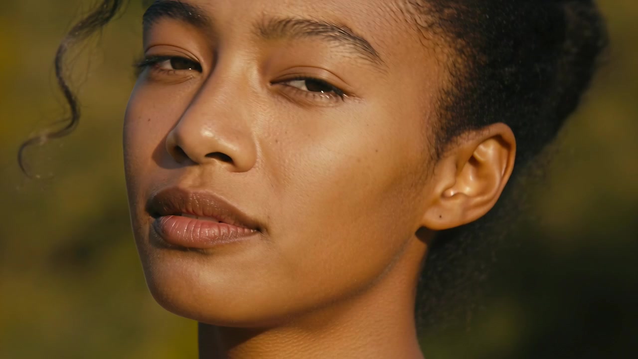 Posing woman camera starting tilting head closing opening eyes at park with stud earring stray curl