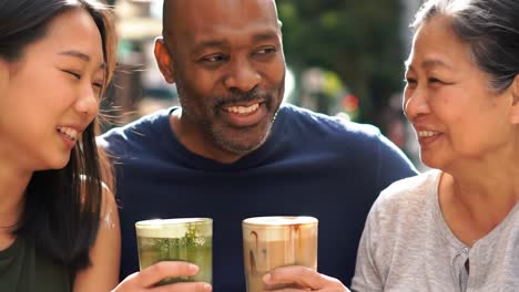 joyful moments: friends sharing laughter and coffee over drinks on a sunlit day, celebrating friendship and connection in a bustling setting