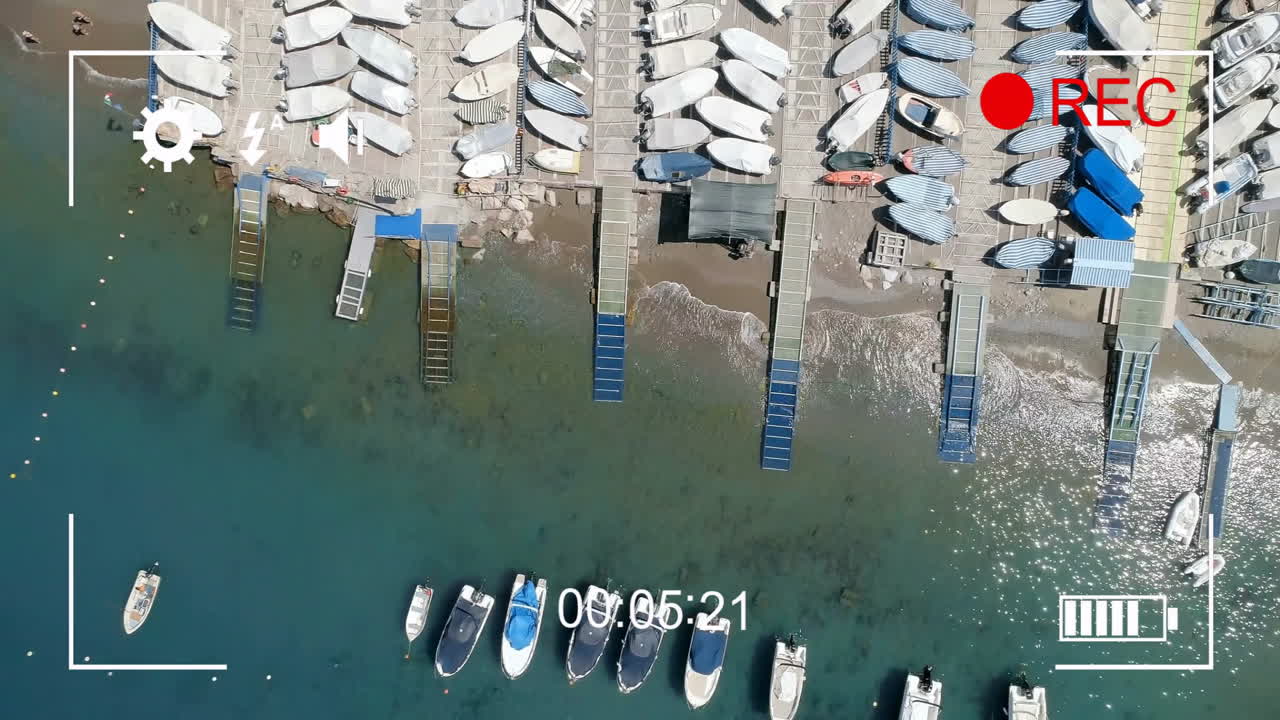 마리나에 정박한 배의 항공 시각과 녹음 타이머 및 설정 아이콘의 애니메이션