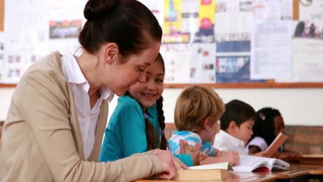 Lehrer-Hilft-Einem-Kleinen-Mädchen-Während-Des-Unterrichts-Beim-Lesen