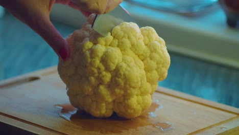 Close-Up-of-Female-Hands-With-Kitchens-Knife-Cutting-White-Cauliflower-Vegetable-as-Vegan-Meal-Preparation,-Static-Full-Frame-Close-Up-Slow-Motion