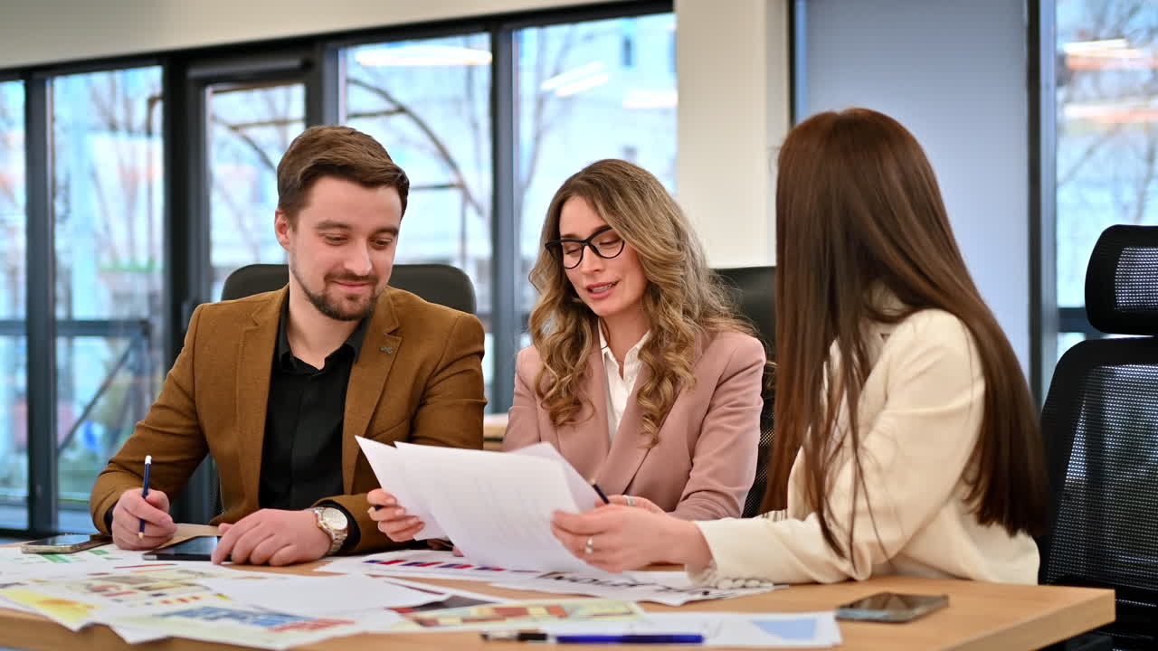 Riunione di lavoro in un ufficio, persone che discutono di affari di lavoro usando dei documenti. Rallentatore