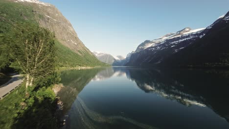 Picturesque-coast-road-of-lake-Lovatnet-in-Norway,-aerial-drone-view