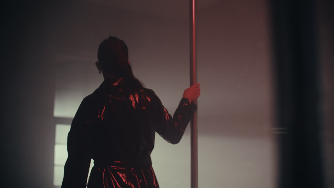 Woman Pole Dancing in a Dark Studio