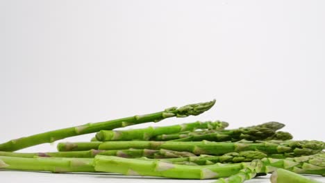 Asparagus-stalks-bouncing-on-white-backdrop-in-slow-motion