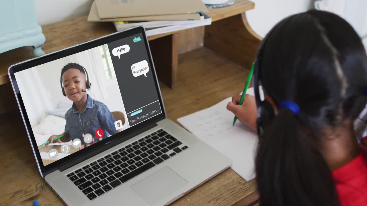 Schoolgirl using laptop for online lesson at home, with her colleague and web chat on screen