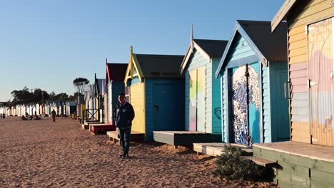 colorful beach huts with a person walking