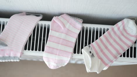 pink and white striped socks drying on radiator