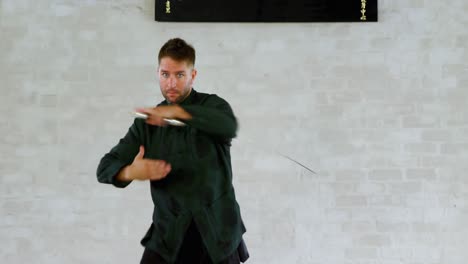 un luchador de kung fu practicando artes marciales con la espada 4k