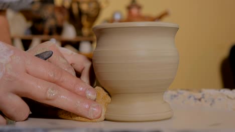 taza de conformación de alfarero profesional con herramienta especial en taller de cerámica