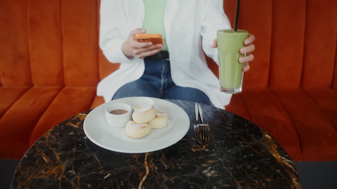 카페에서 스무시와 시르니키를 즐기는 여자