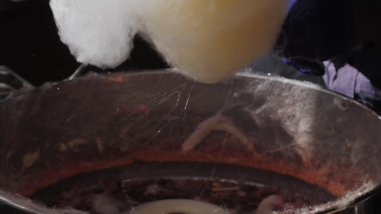 Making cotton candy or candy floss close-up. A spun sugar confection that resembles cotton. Local food festival with street food. . High quality 4k footage