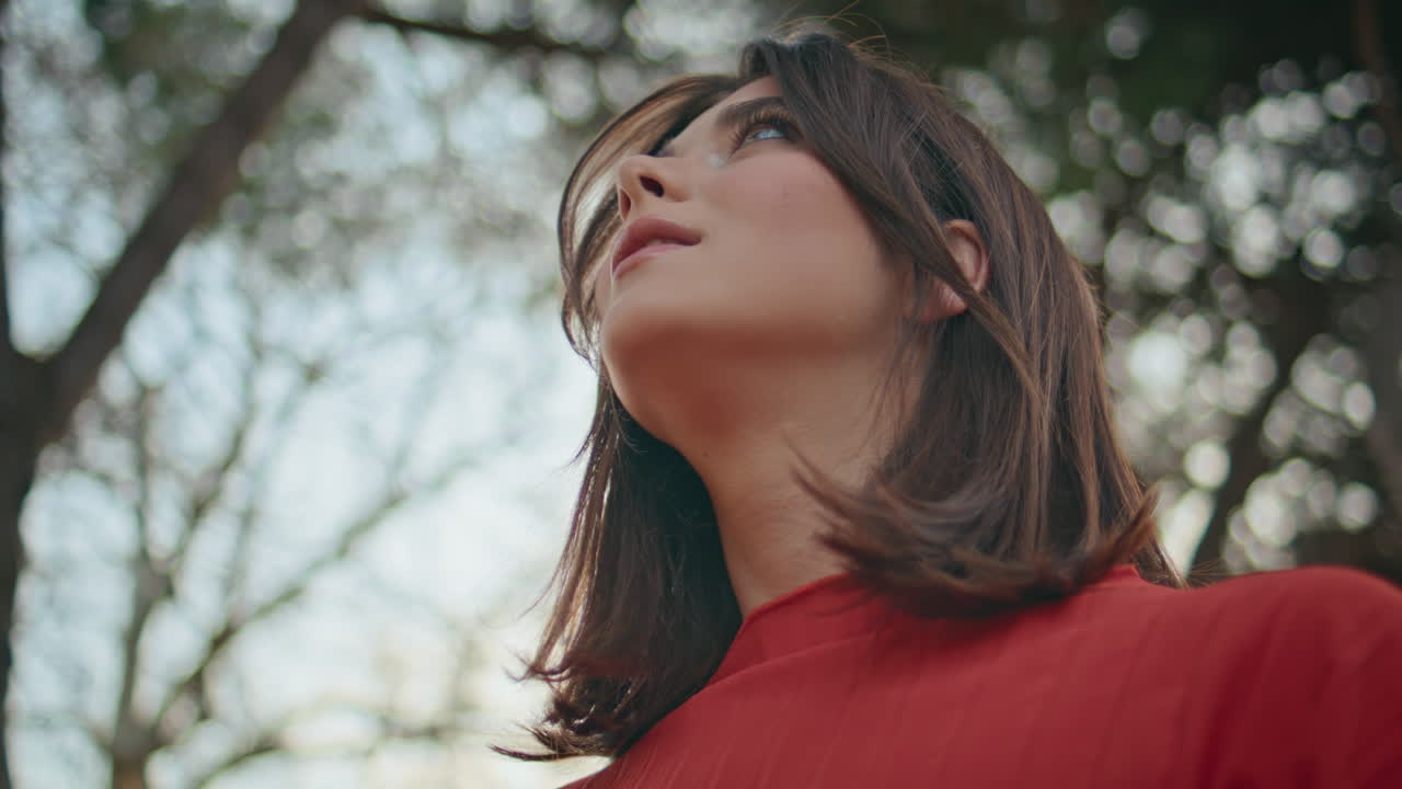 Charming lady adjusting hairstyle walking garden closeup. Girl looking distance