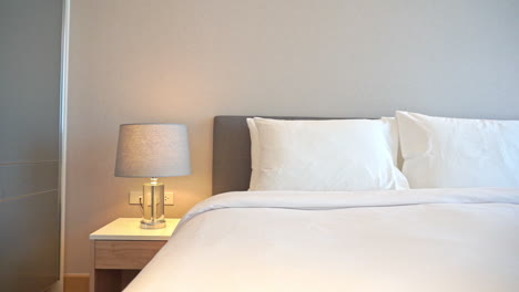 clean crisp white bed linen and golden lamps on bedside tables glowing in upscale luxury resort bedroom