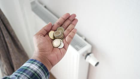 coins in hand near radiator