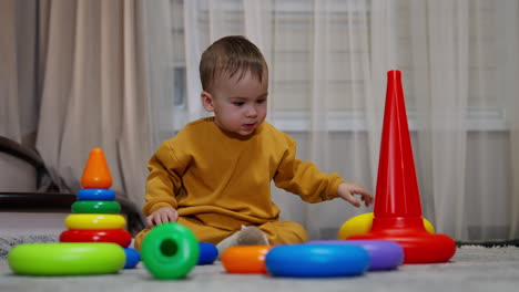 toddler playing with colorful stacking rings and a cone
