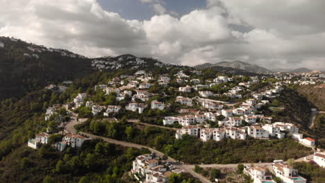 Creciente-Aéreo-Pequeño-Pueblo-Montañas-Casas-Blancas-árboles-Verdes-Día-Nublado