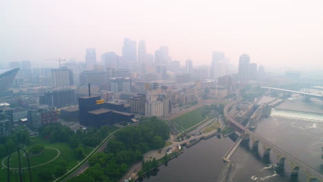 downtown minneapolis enveloped in a thick blanket of wildfire smoke, creating a hazy and obscured cityscape