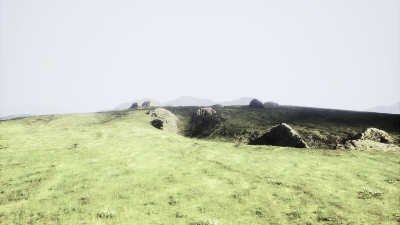 Vast green landscape with rocky terrain under a bright sky