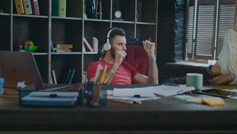 propietario de una pequeña empresa descansando después de un día de trabajo. hombre escuchando música en el lugar de trabajo