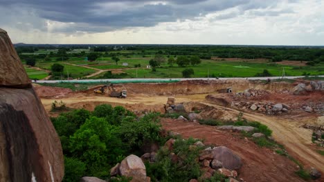 a truck loading sand through excavators in background crop fields lands with clouds and sky in telangana, india. day time, push back, drone shot, 4k