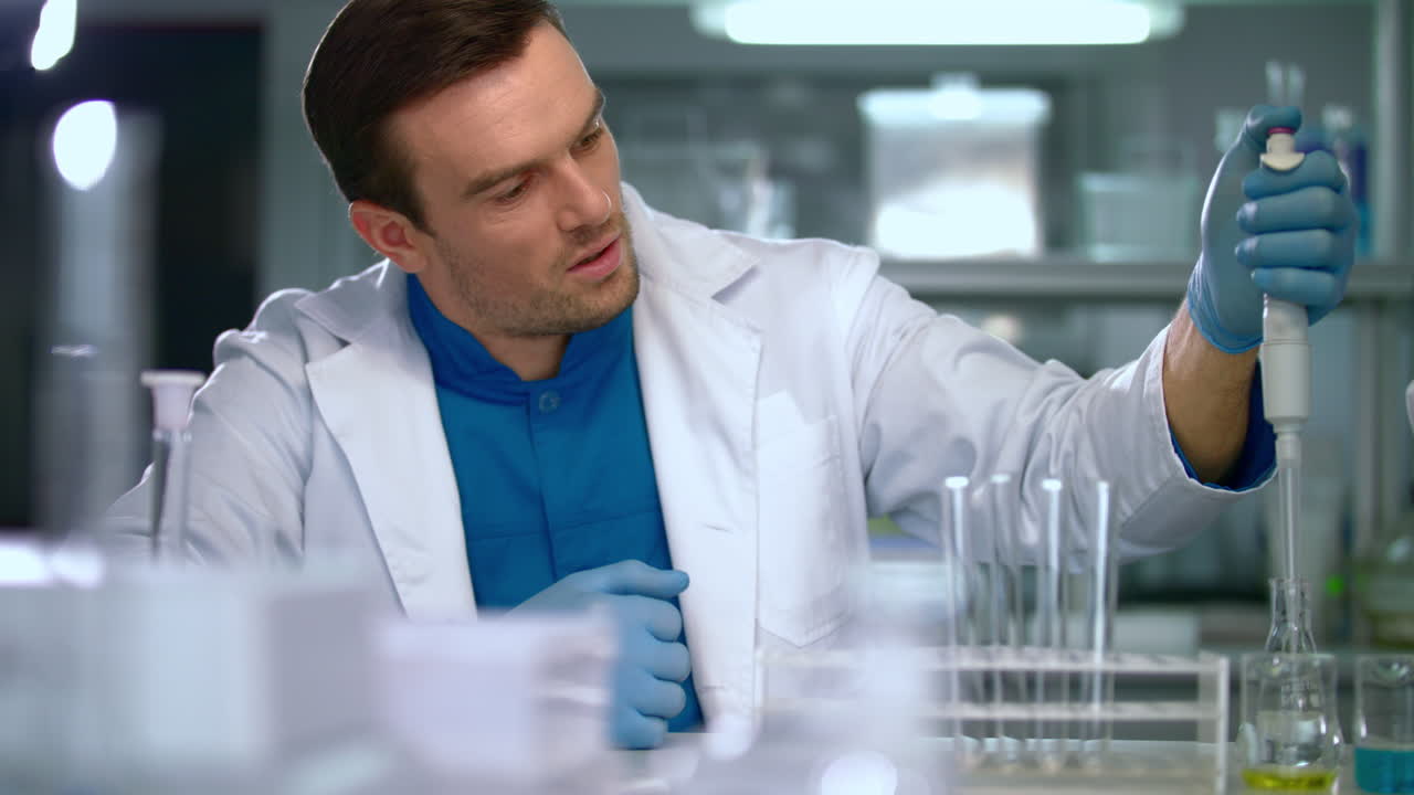 Scientist man using pipette in lab. Lab worker using laboratory equipment