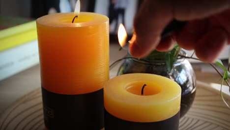 two scented candles being lit on an interior coffee table