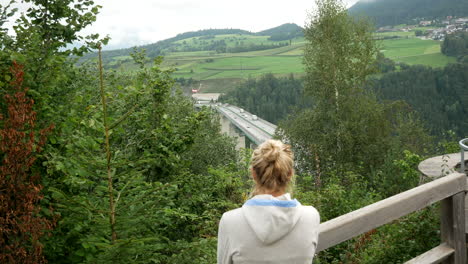 young blond girl enjoying beautiful wide view of brenner motorway in austria during holiday trip