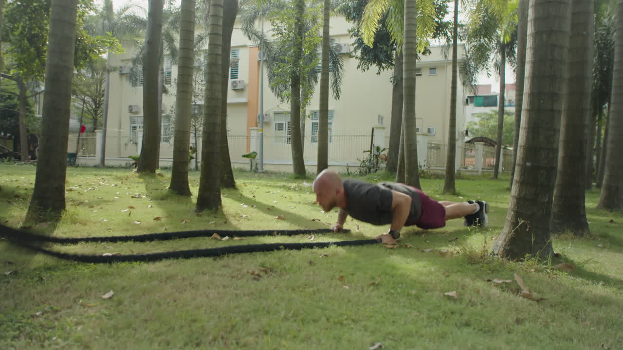 Man Doing Battle Rope Push Ups in Park