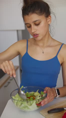 woman preparing and eating a salad
