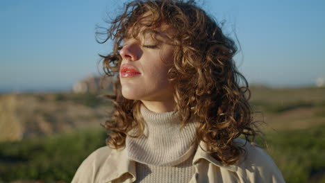 mujer suave disfrutando de la luz del sol ojos cerrados primer plano vertical. chica serena relajante