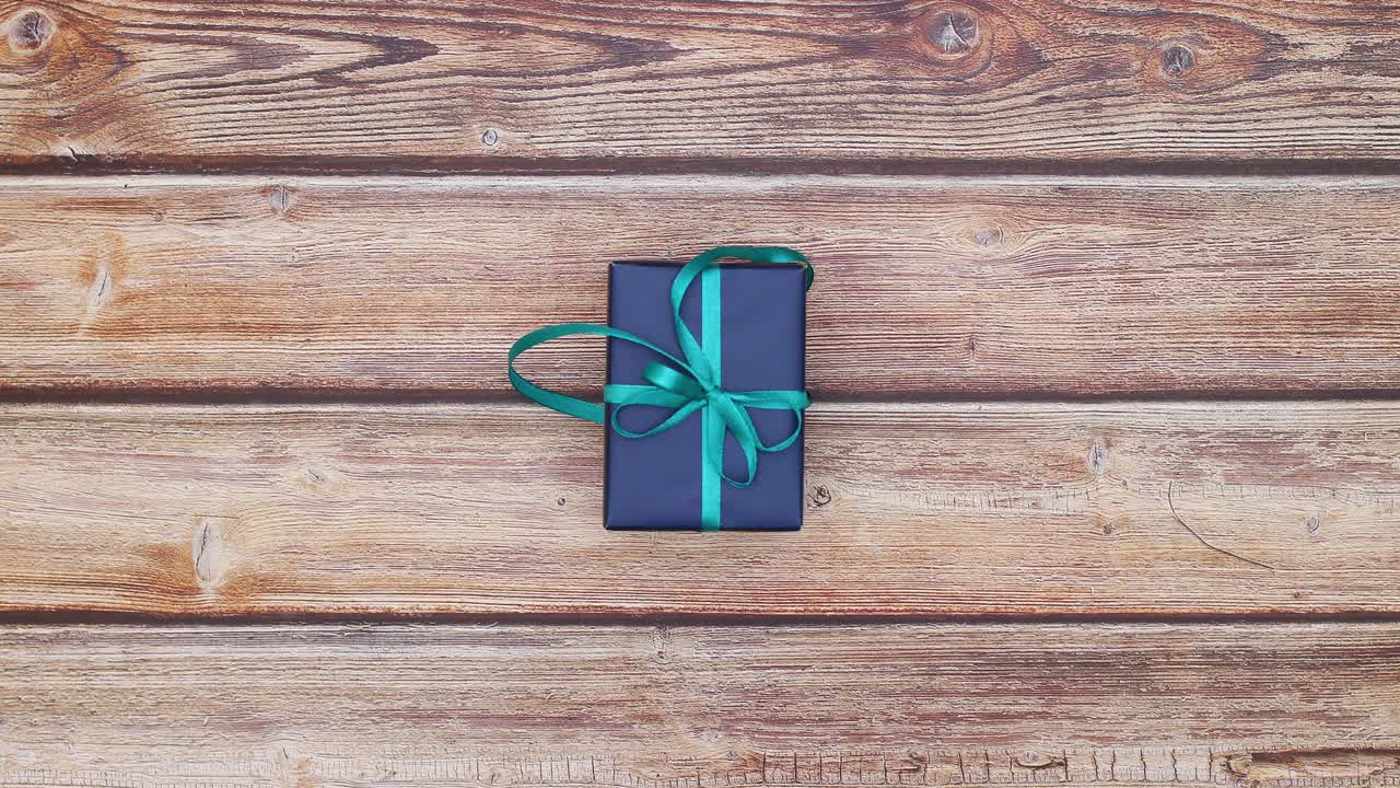 cajas de regalos azules con cintas azules cambiando rápidamente en la mesa de madera - detener el movimiento de bucle