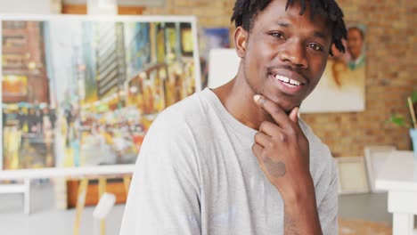 Portrait-of-smiling-african-american-male-painter-in-artist-studio