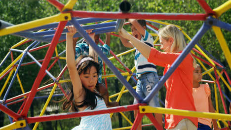 Trainer-assisting-schoolkids-while-playing-in-playground