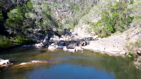 Drone-aerial-of-landscape-bushland-river-lake-ecosystem-rock-formation-trees-mountain-Nethercote-falls-Eden-South-Coast-tourism-travel-Australia-4K