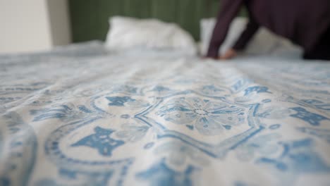 making a bed with floral patterned sheets