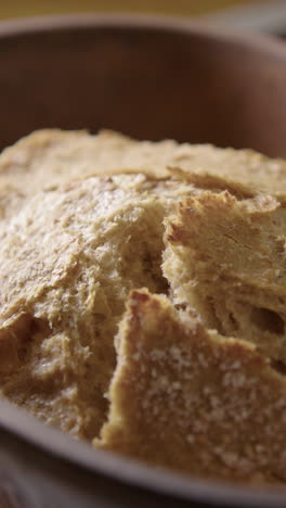 clay baker lid is lifted to reveal freshly baked steaming organic sourdough loaf