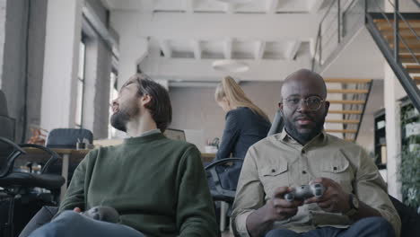 coworkers playing video games in office